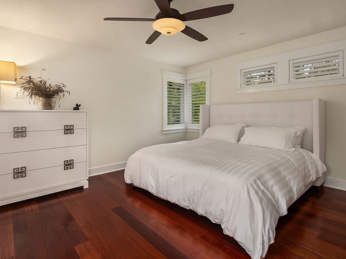 Bedroom with hardwood floors and plantation shutters